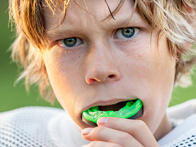 A young male athlete with a mouthguard, looking directly at the camera.